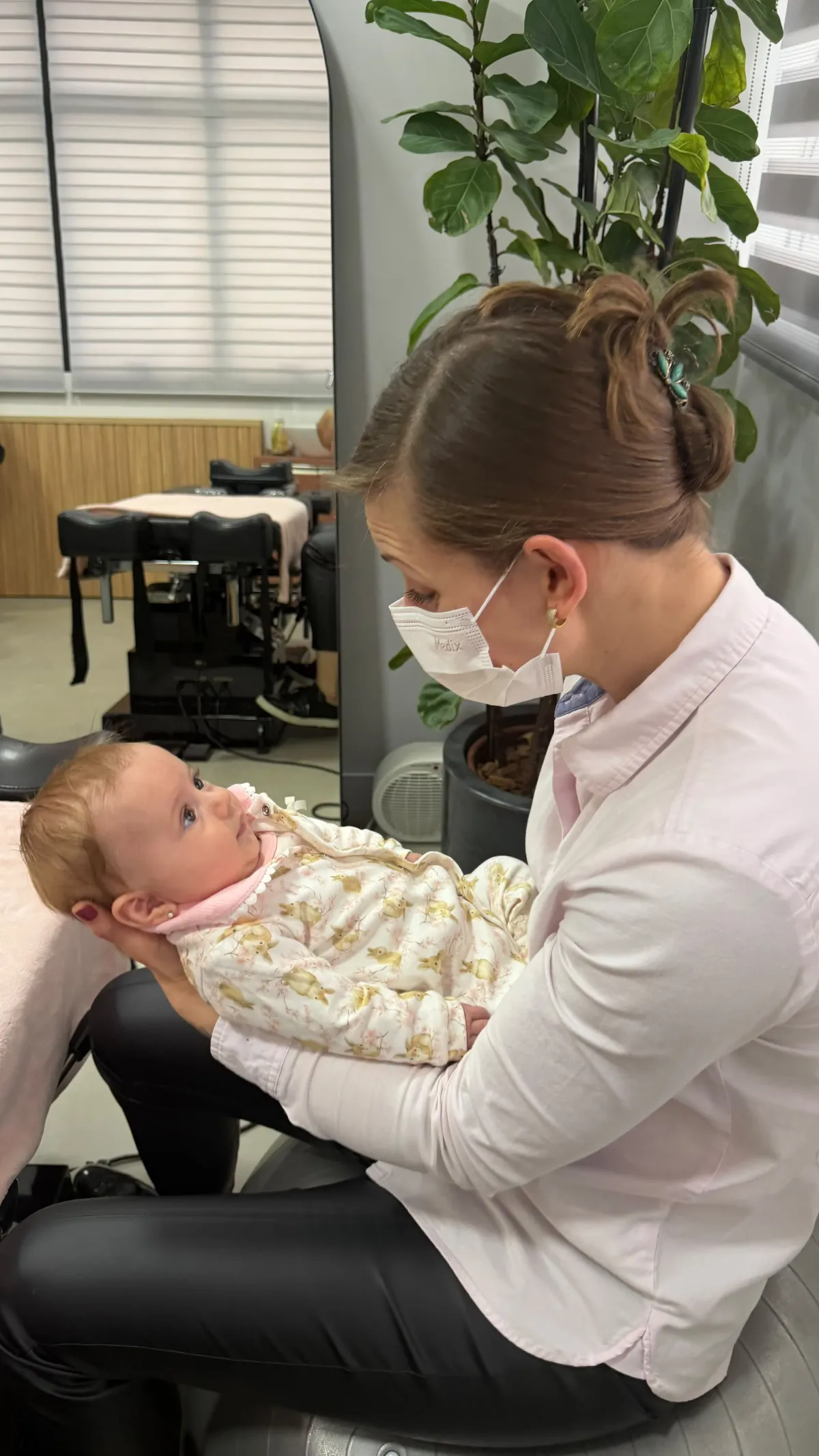 Dra. Simone Pryjmak segurando um bebê durante atendimento individualizado